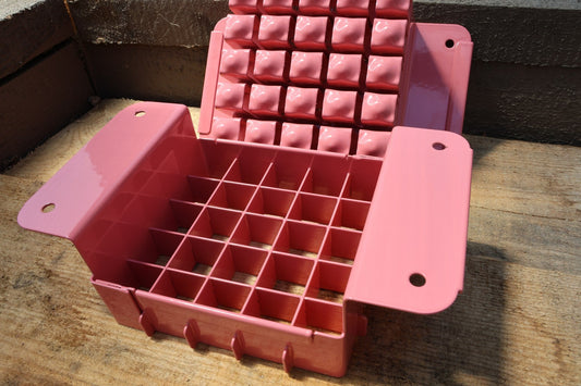 Nano 25 soil blocker in pink, open to show the 25-cell grid and the block-forming plate