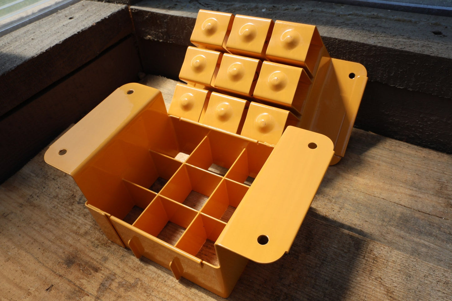 Angled view of the tangerine Nano 9 showing nine cells for 1.5 inch soil blocks