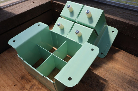 Nano 4 soil blocker in green, open to show the 4-cell grid and the dibble block-forming plate