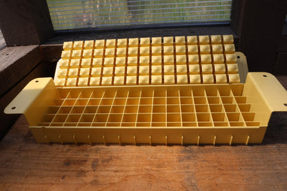 Swift Blocker Mini 75 in yellow, open to show the 75-cell grid and the block-forming plate