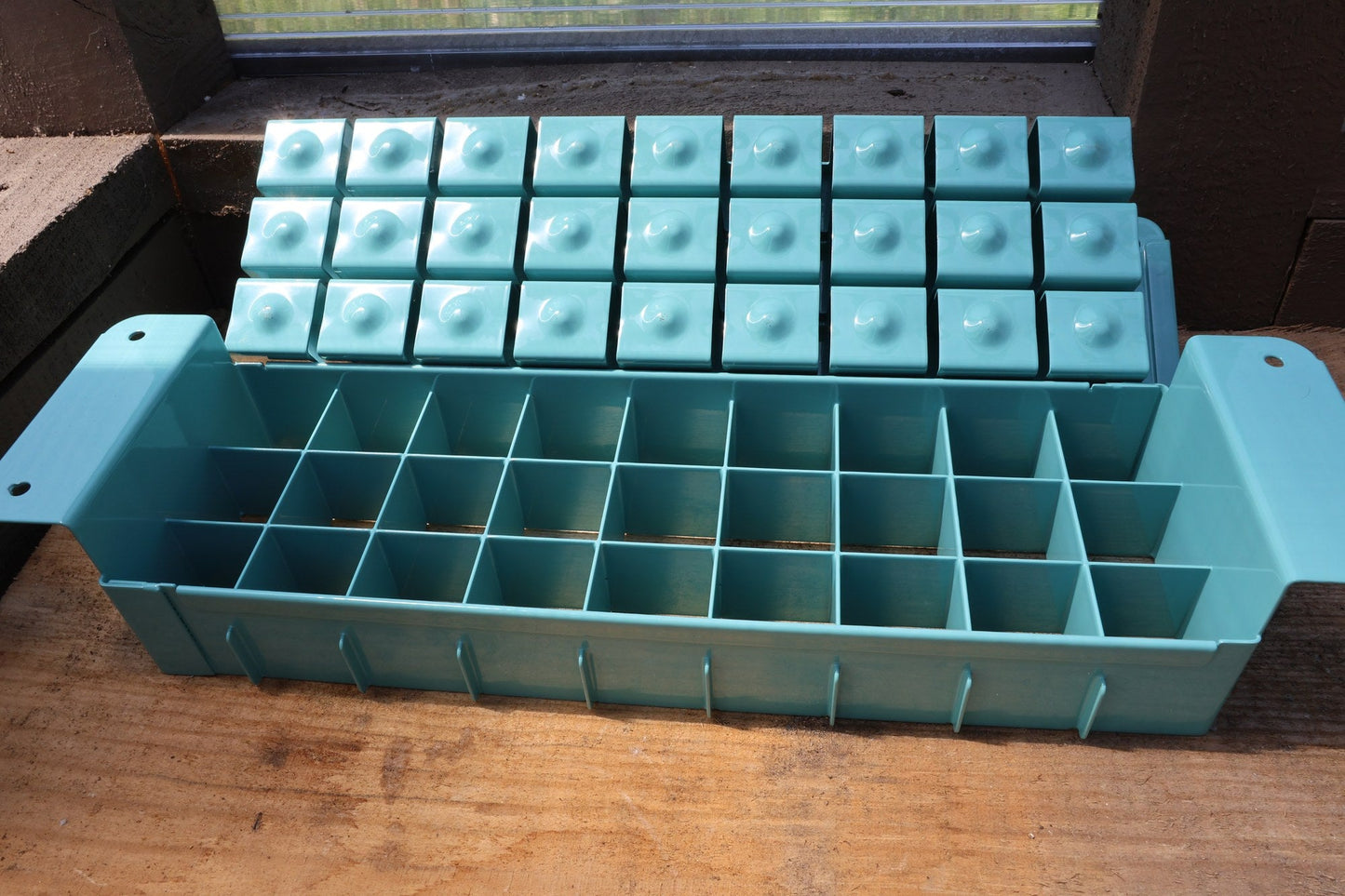 Swift Blocker Mini 27 in teal, open to show the 27-cell grid and the block-forming plate